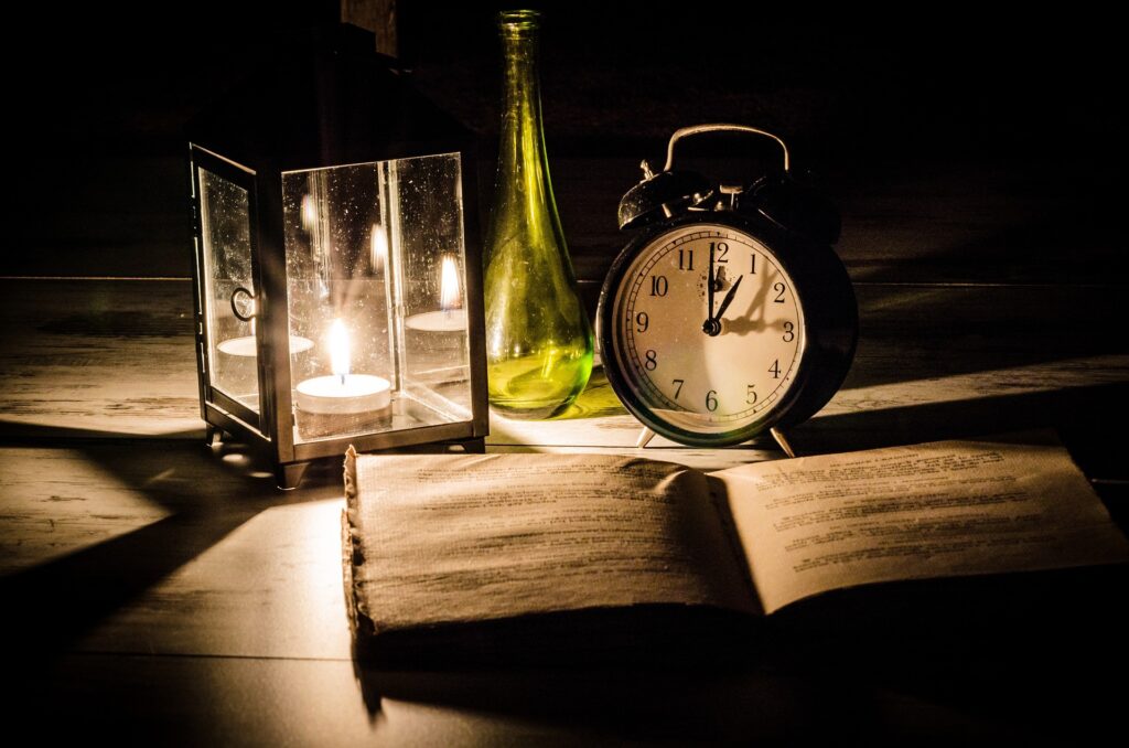 暗がりの中、ノート、時計、ビンが置いてある